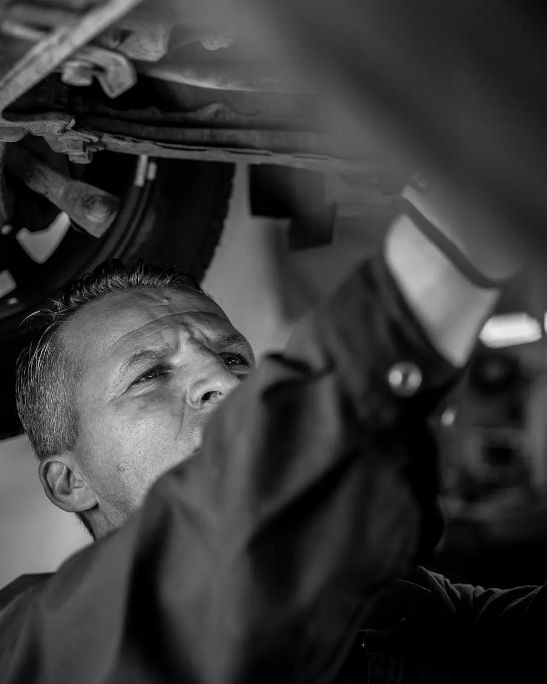 Mechaniker prüft die Unterseite eines Autos